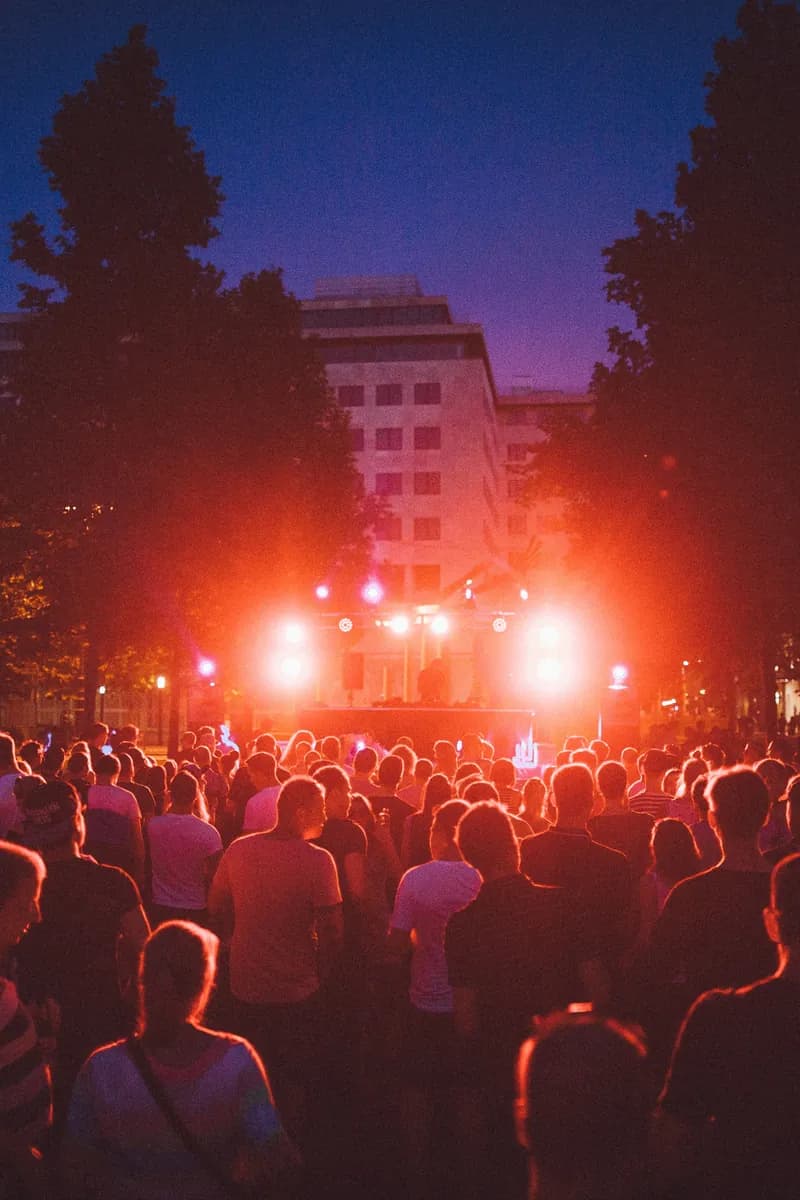 Sfeerbeeld: buitenfestival in de avond met rode podiumlichten