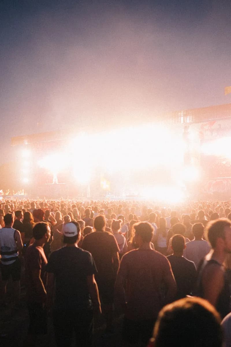 Sfeerbeeld: festivalpubliek voor een verlicht podium bij zonsondergang