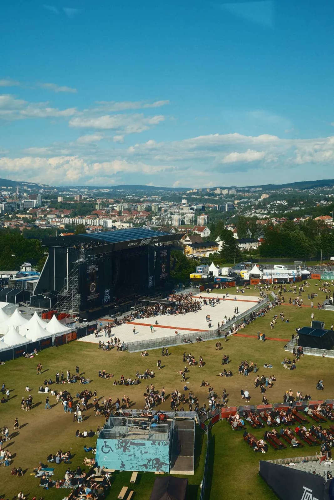 Sfeerbeeld: luchtfoto van een festivalterrein met podium