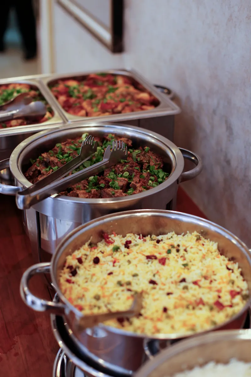Sfeerbeeld: cateringbuffet met warme gerechten in rvs-schalen