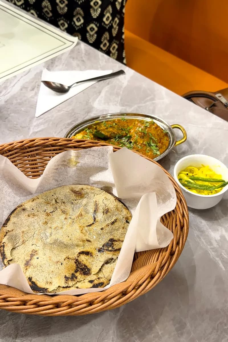 Sfeerbeeld: roti in een mandje met curry en bijgerechten